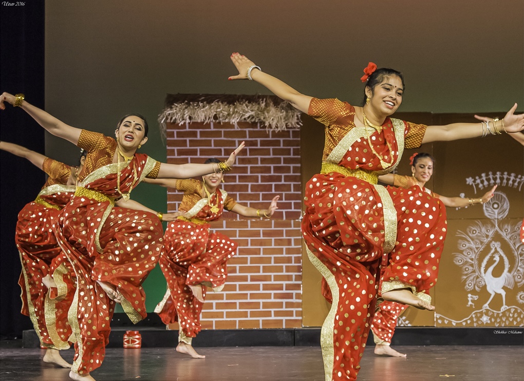 Students performing a group folk dance formation in the studio